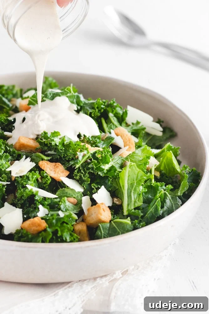 Creamy Tahini Kale Salad 3 Kale Tahini Salad served in a large serving dish with Tahini Salad dressing being poured on top