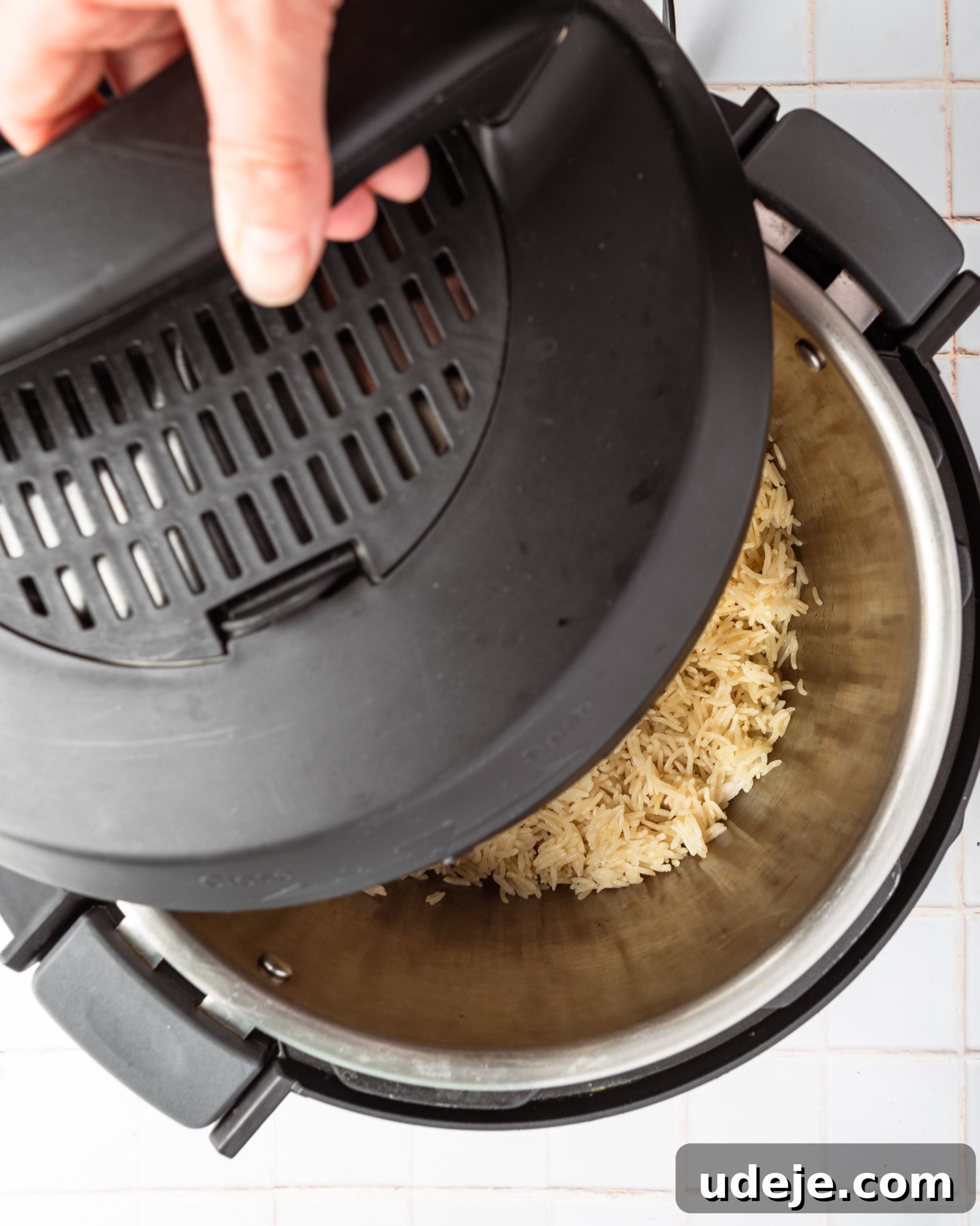 Instant Pot Basmati: Fluffy Perfection in 15 Minutes 12 Cooked basmati rice in the Instant Pot, with the lid placed halfway to allow gentle steaming and drying, on a white tiled background. This final rest ensures perfect grain separation.
