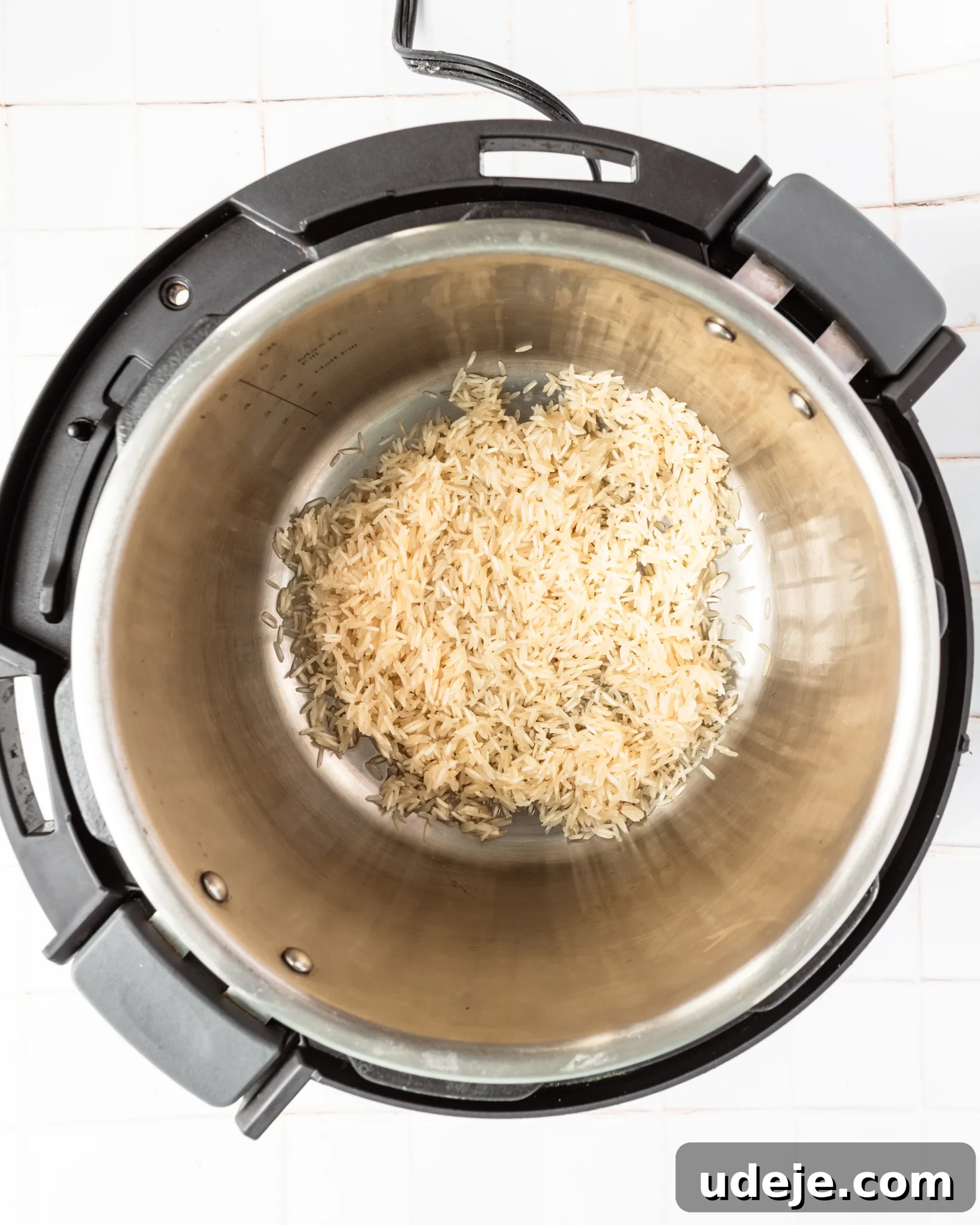 Instant Pot Basmati: Fluffy Perfection in 15 Minutes 7 Basmati rice lightly toasting in oil within the Instant Pot, set on a white tiled background. This step enhances flavor and grain separation.