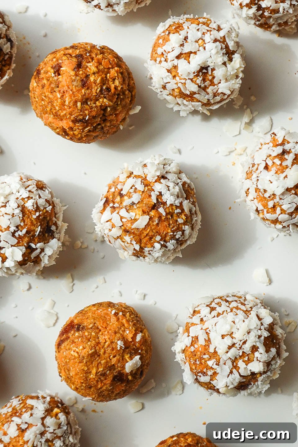 Carrot Cake Power Bites 3 Multiple vegan carrot cake energy balls, perfectly rounded and coated in shredded coconut, arranged on a pristine white plate.