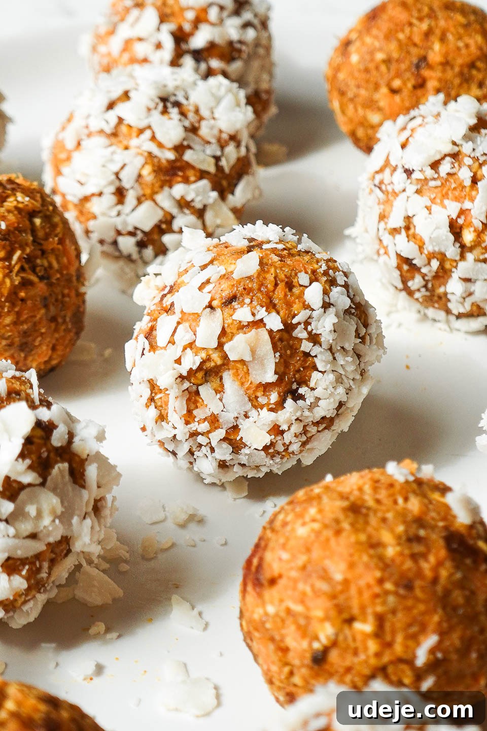 Carrot Cake Power Bites 4 Close-up view of no-bake carrot cake energy balls, perfectly round and coated in shredded coconut, ready to be enjoyed.