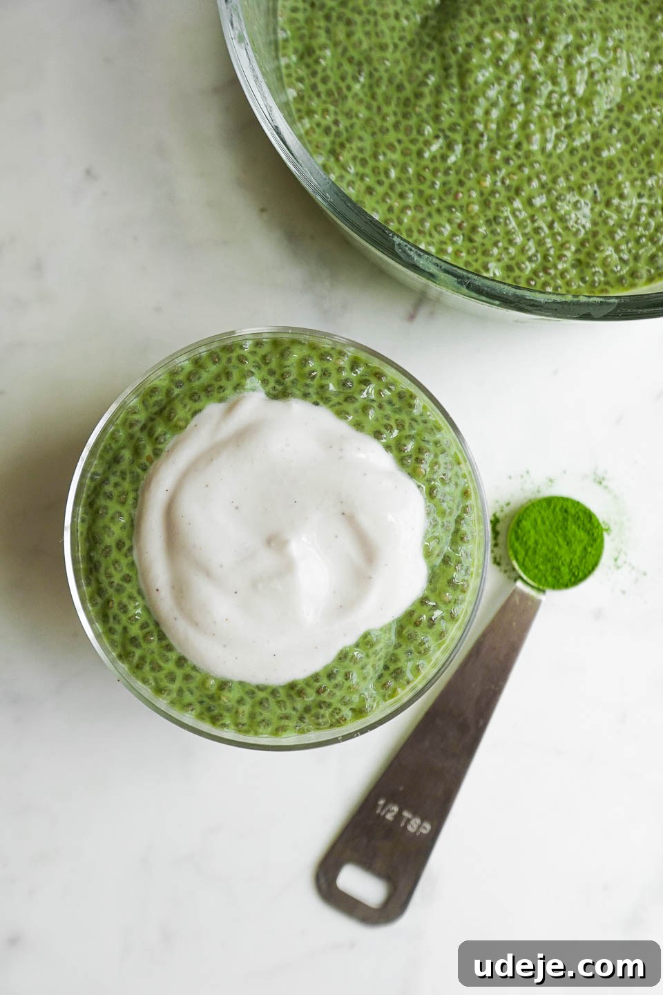 Energizing Matcha Chia Delight 4 Overhead shot of two glass jars filled with creamy matcha chia pudding, one topped with yogurt, highlighting its appeal for a quick and healthy meal.