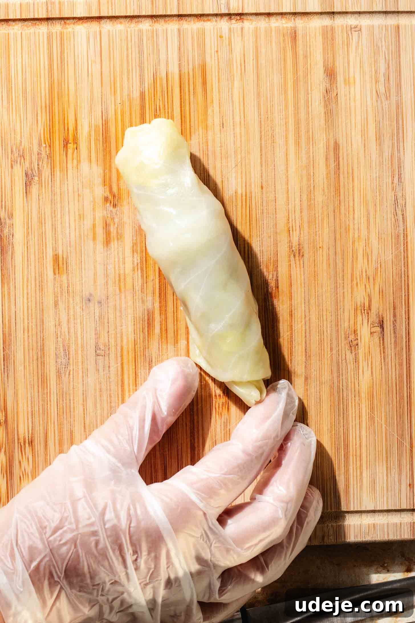Irresistible Beef and Rice Cabbage Rolls 12 A beautifully rolled, blanched cabbage leaf with its savory ground beef filling, presented on a light wooden background.