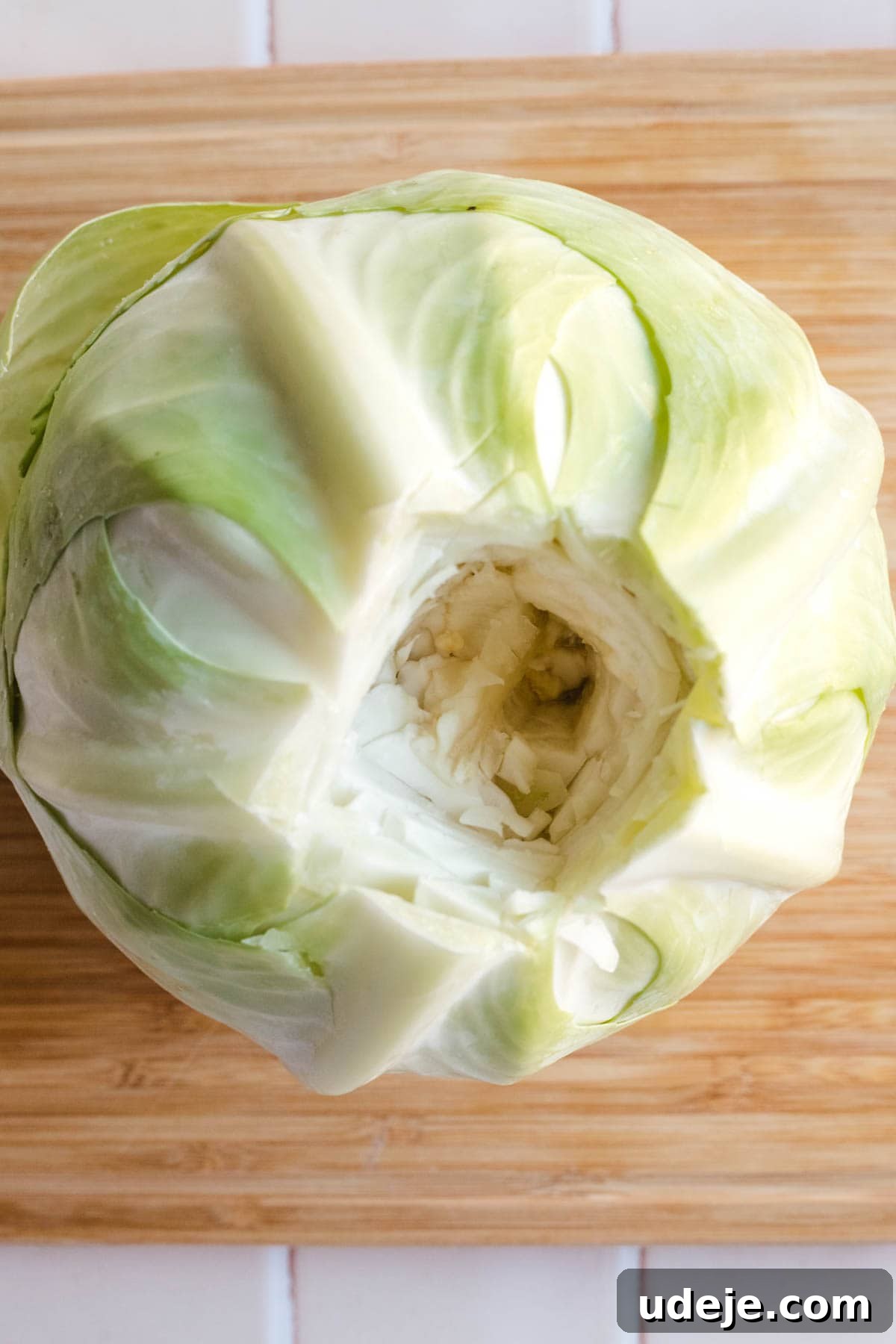 Irresistible Beef and Rice Cabbage Rolls 4 A vibrant green cabbage with its root neatly cored out, indicating preparation for leaf separation.
