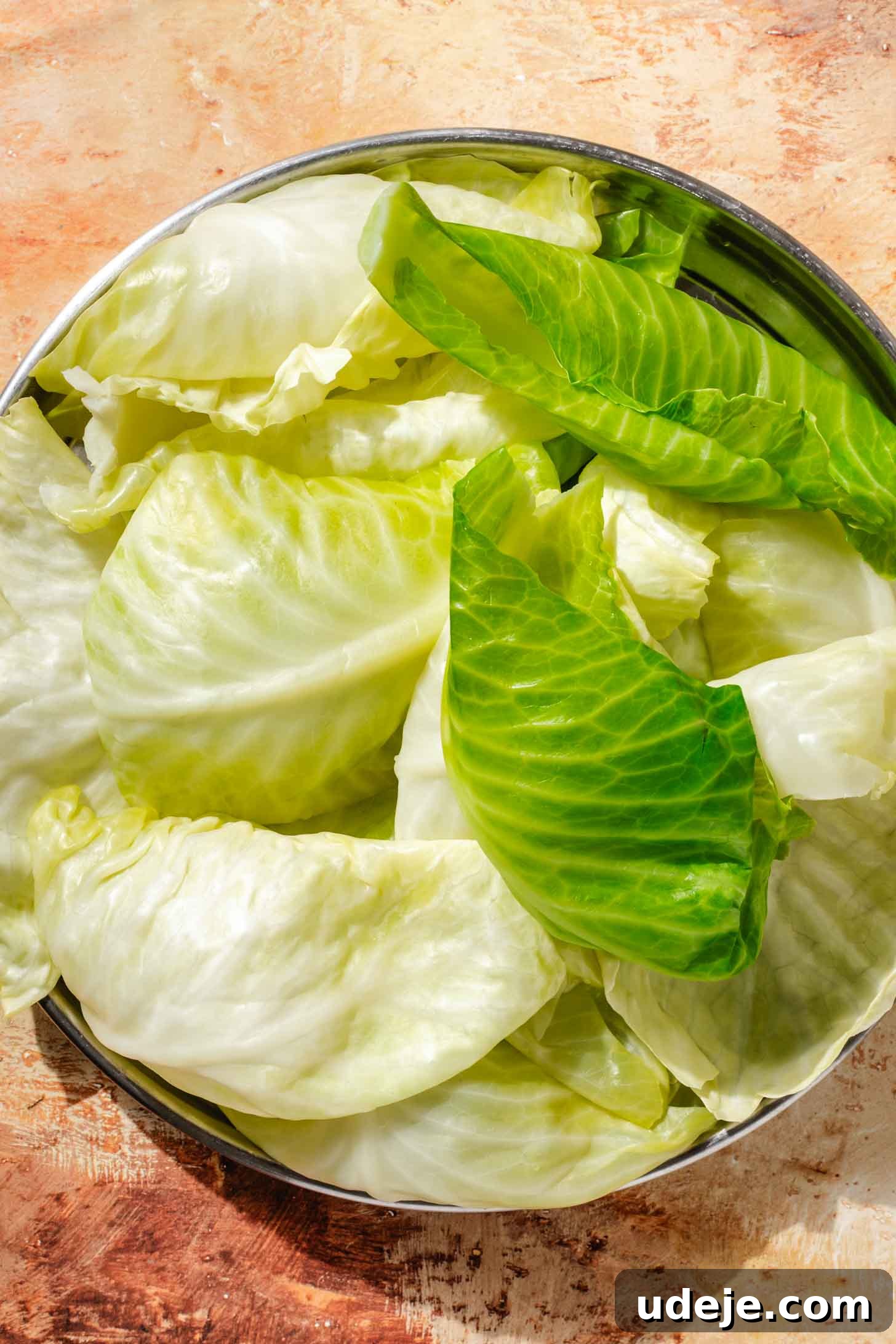 Irresistible Beef and Rice Cabbage Rolls 5 Softened cabbage leaves gathered in a metal bowl, ready for the next step in preparing stuffed cabbage rolls.
