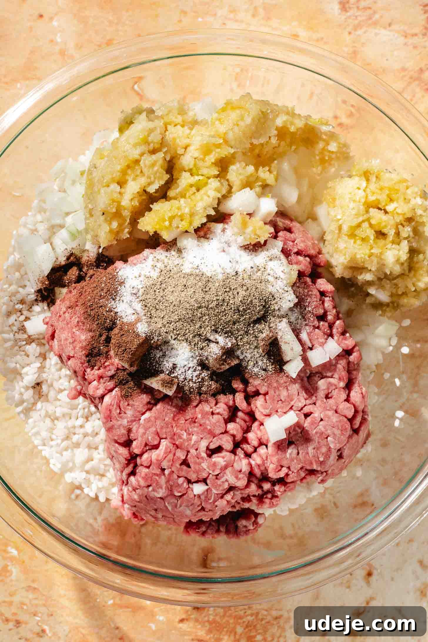 Irresistible Beef and Rice Cabbage Rolls 6 A glass bowl holds the raw ground beef mixture, featuring garlic, onions, short-grain rice, and seasoning, all ready to be combined into a savory stuffing.