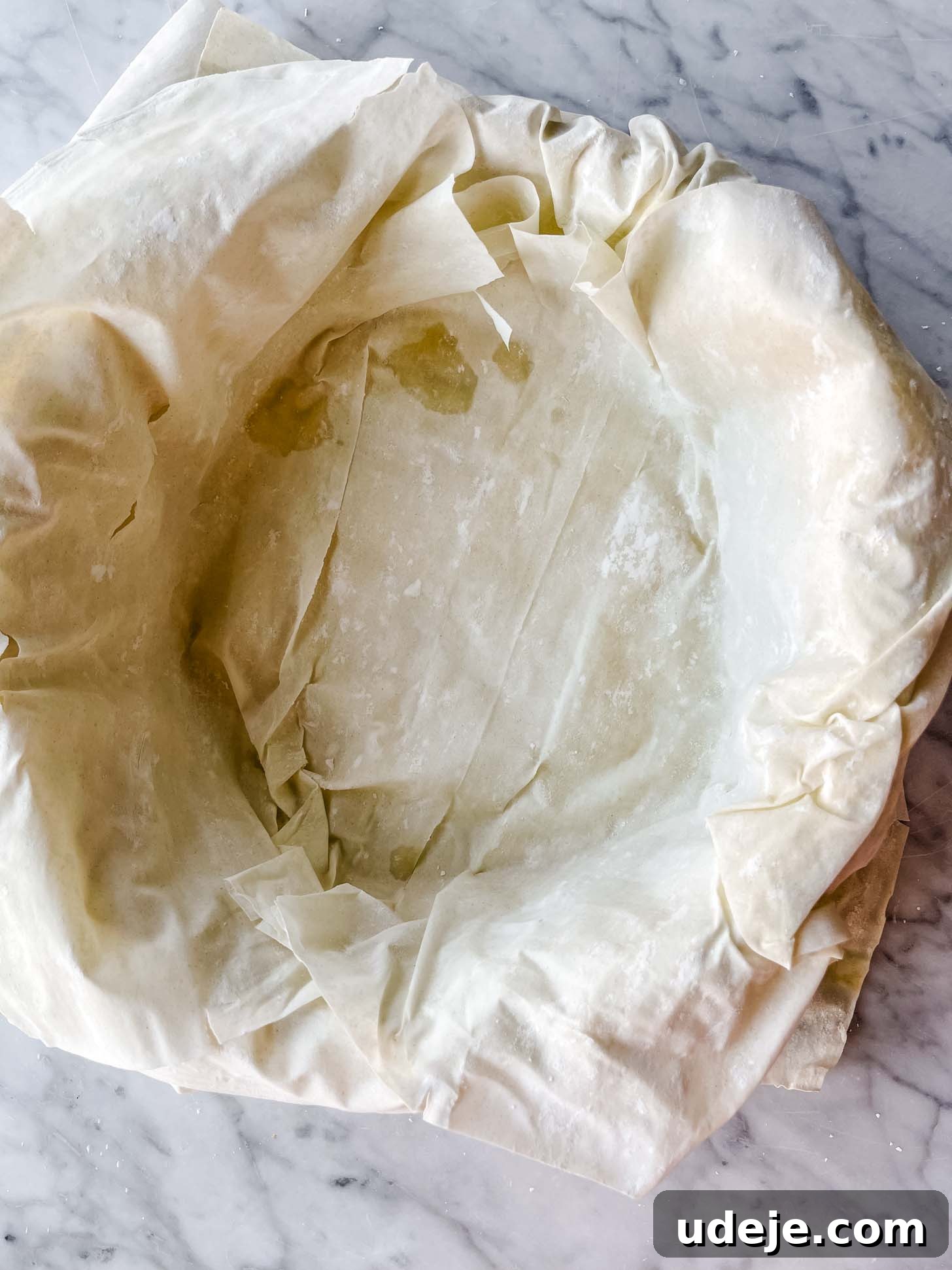 Apple Pie Meets Baklava 11 Multiple layers of phyllo pastry lining a springform pan, with edges overhanging.