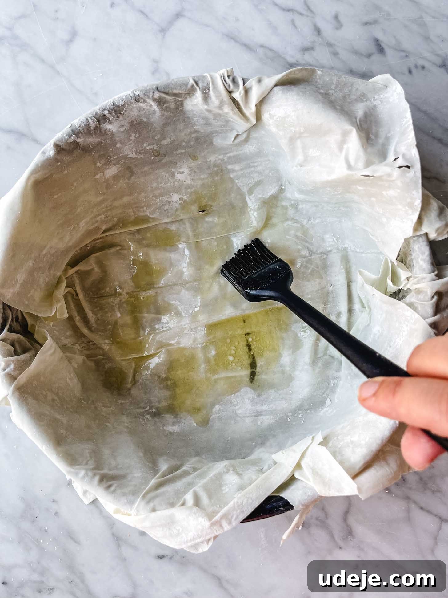Apple Pie Meets Baklava 10 A pastry brush buttering the phyllo layers in a springform pan.