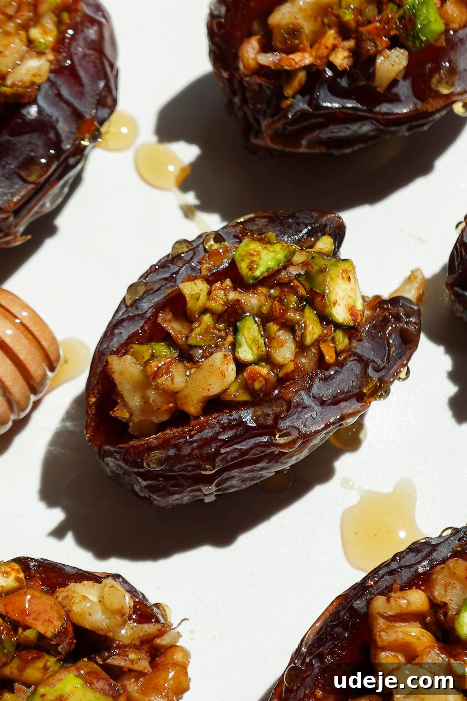Gourmet Baklava-Filled Dates 3 Close-up of a baklava stuffed date showing pistachio and walnut filling inside a soft medjool date with a drizzle of honey