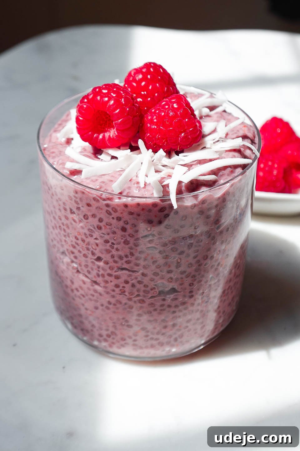 Raspberry Chia Bliss 4 Raspberry chia pudding in a glass jar topped with fresh raspberries and coconut flakes