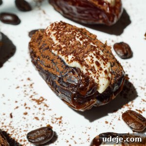 Tiramisu Stuffed Medjool Dates, beautifully arranged and dusted with cocoa powder, inviting you to taste.