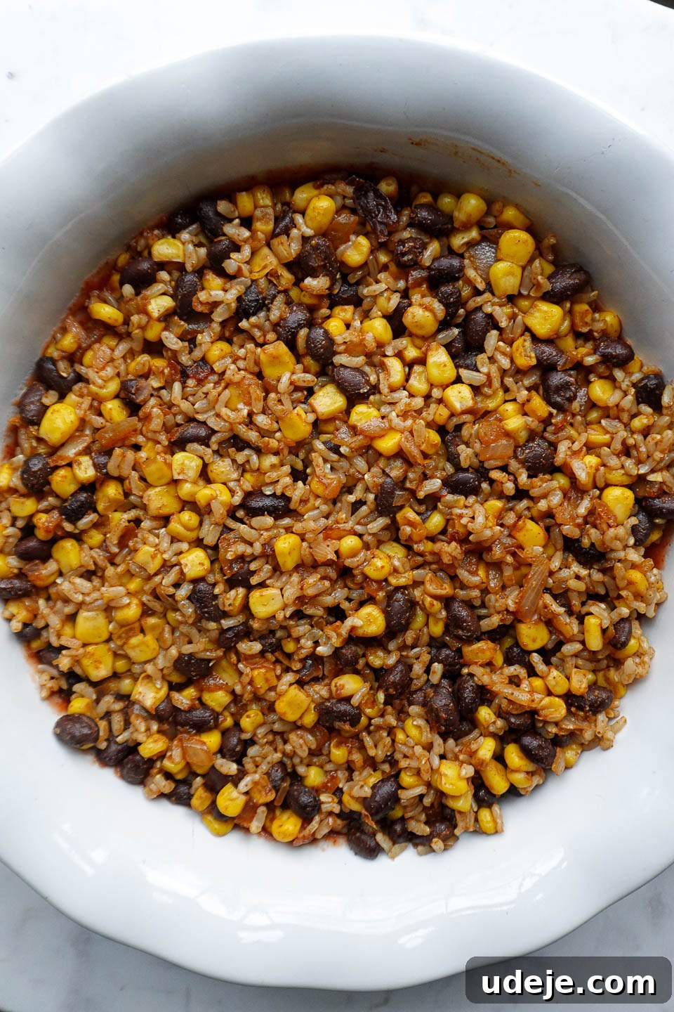 Plant Based Mexican Rice Bake 5 Half of the rice and bean mixture added over the salsa layer in the baking dish