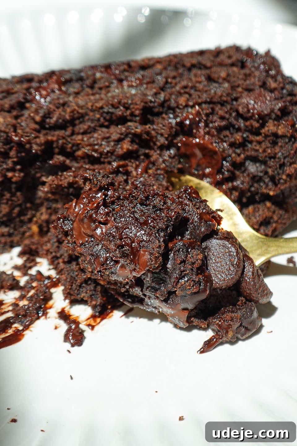 Wholesome Vegan Gluten-Free Chocolate Banana Bread 5 A delectable slice of healthy chocolate banana bread resting on a plate with a spoon, showcasing its soft interior and irresistible melty chocolate chips.