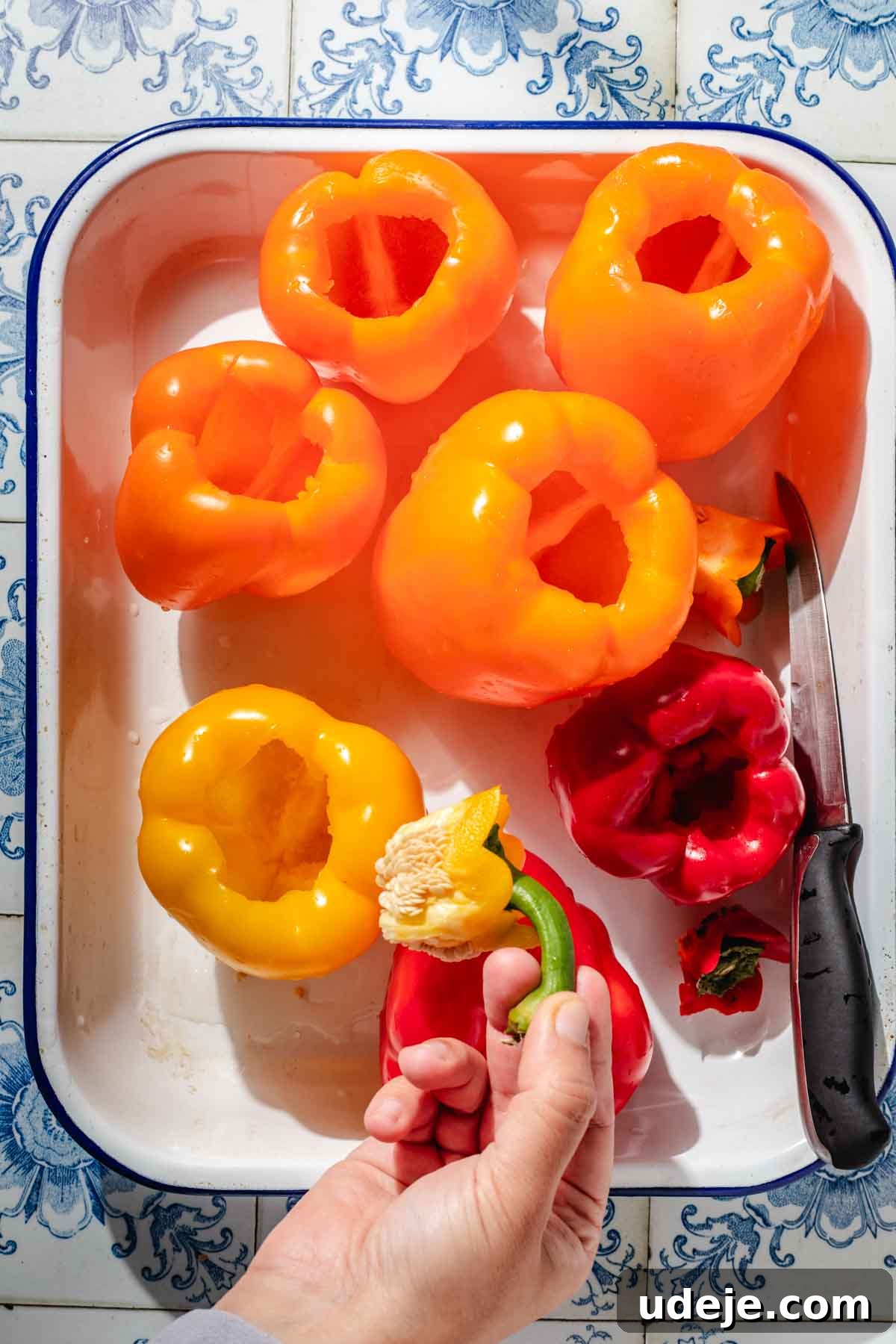 Mediterranean Veggie Stuffed Peppers 7 Large yellow, orange and red bell peppers that are hollowed out using a knife, placed in a large enamel baking pan.