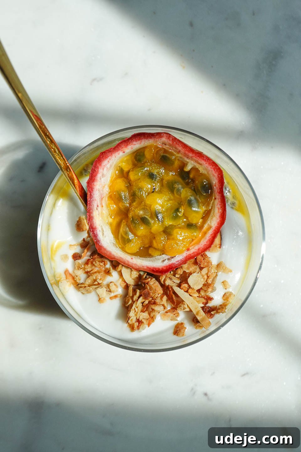 Tropical Passionfruit Chia Pudding 3 Overhead shot of jar of passionfruit chia pudding with half a passionfruit on top, garnished with granola