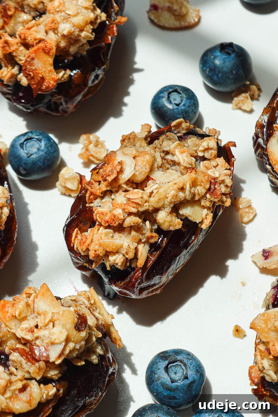 Blueberry Crisp Date Gems 2 Close-up of Blueberry Crisp Stuffed Dates with nutty oat topping on a white plate, ready to be enjoyed