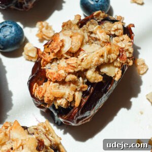 Blueberry Crisp Stuffed Dates on a white plate garnished with fresh blueberries