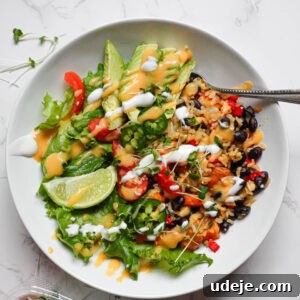 Plant-Powered Sweet Potato Burrito Bowl 5 Overhead shot of a vegan burrito bowl with brown rice, roasted sweet potatoes, black beans, and fresh toppings in a ceramic bowl