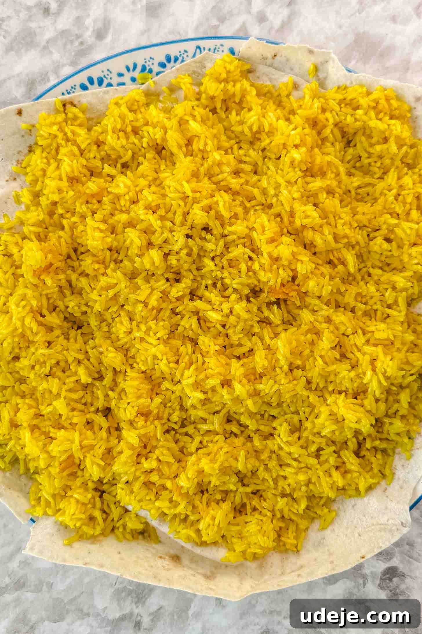 Mansaf: Jordan's Tangy Lamb Masterpiece 13 A blue and white patterned plate with thin pieces of markook bread and yellow rice on top.