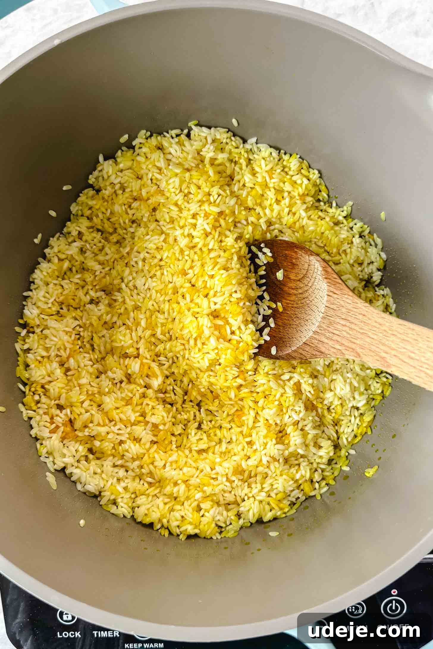 Mansaf: Jordan's Tangy Lamb Masterpiece 8 A grey pot with yellow rice and a wooden spoon.