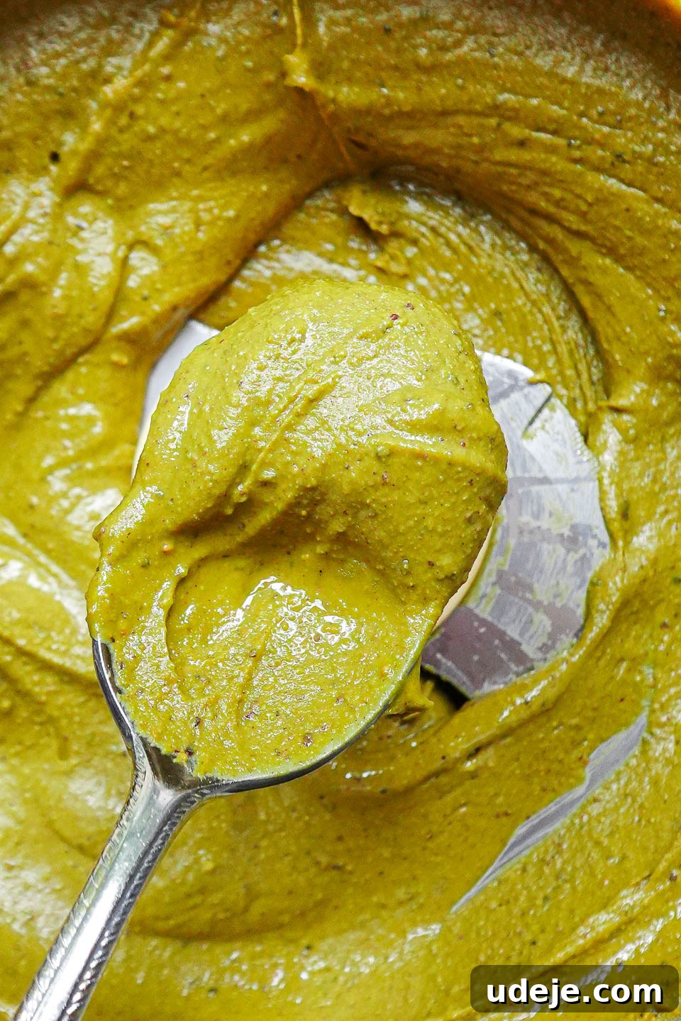Artisan Pistachio Spread 5 Close-up shot of incredibly smooth and vibrant pistachio butter on a spoon, ready to be tasted.