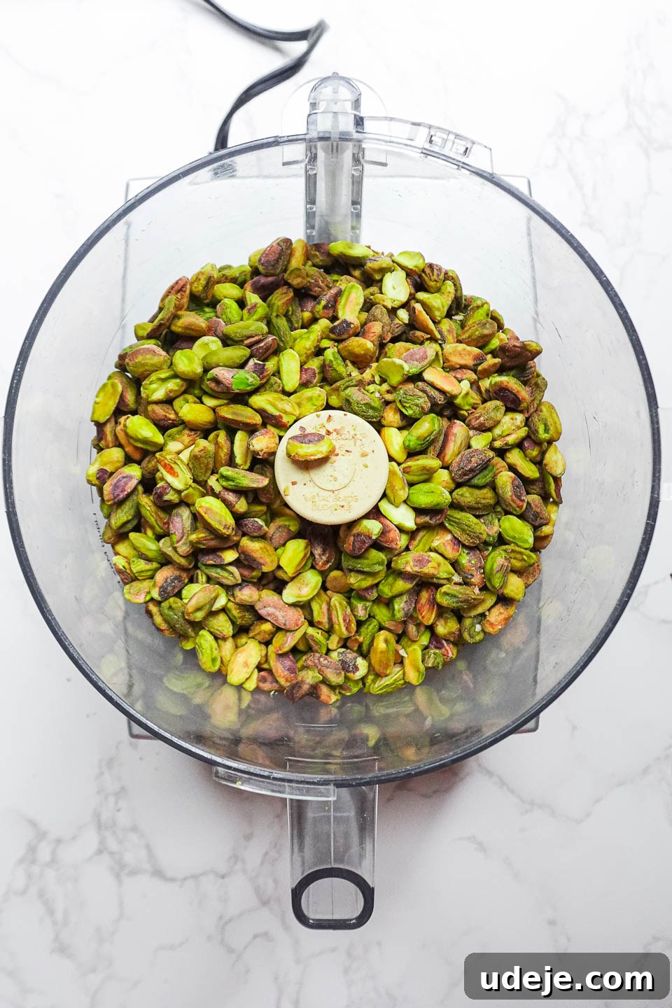 Artisan Pistachio Spread 7 Initial stage of pistachios in a food processor, starting to break down into crumbs for butter.