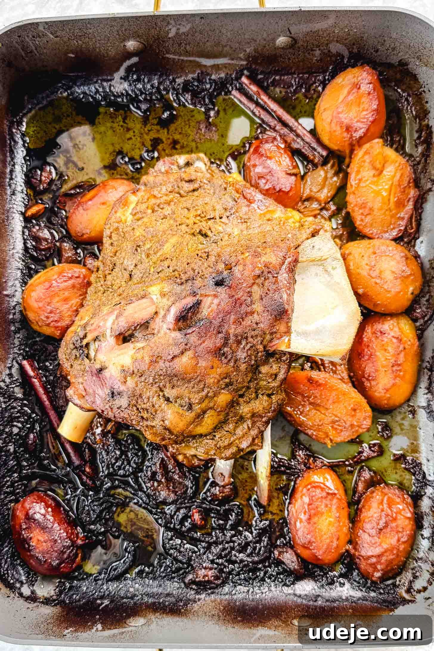 Fall-Apart Tender Lamb Haneeth 10 Roasted lamb shoulder with roasted halved potatoes and cinnamon sticks in a large roasting pan.