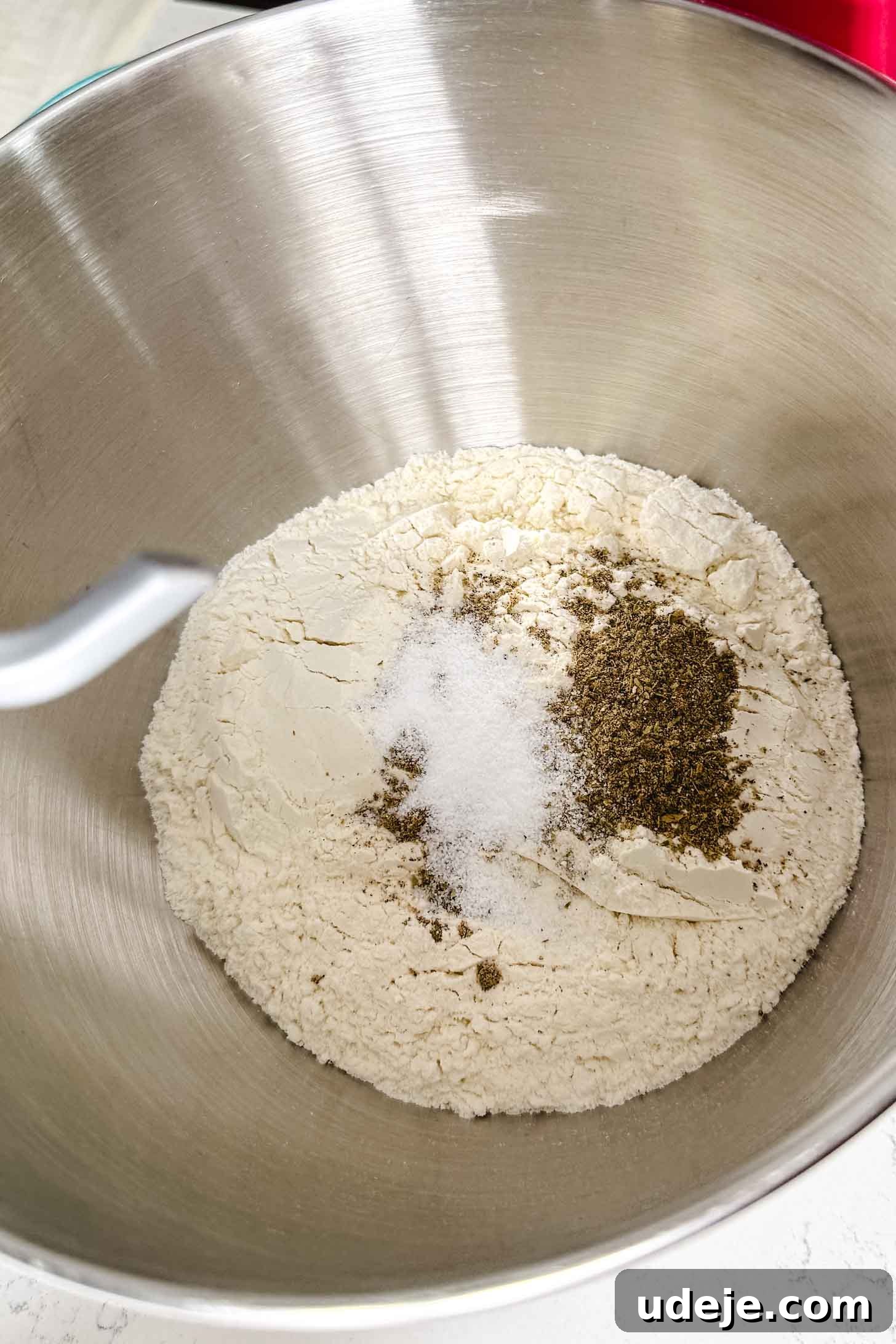 Iraqi Kleicha A Sweet Tradition with Date or Walnut 5 A large metal mixing bowl contains flour, salt, and pepper, with a dough hook visible at the side—ready to start making Kleicha.