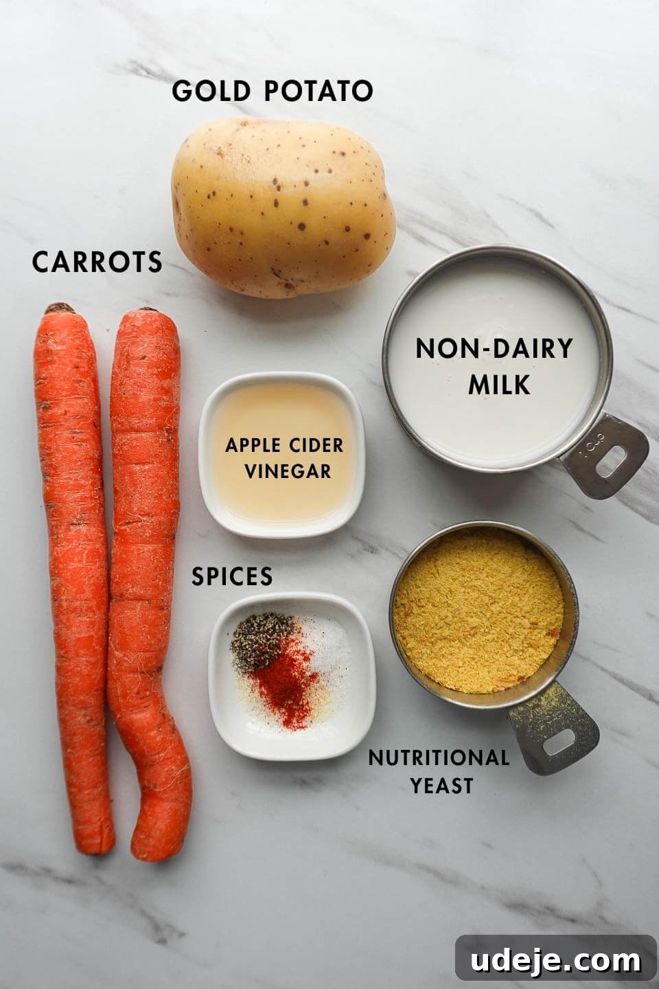 Golden Vegan Cheese Sauce Potato And Carrot Infusion 5 Ingredients for vegan cheese sauce laid out, including potatoes, carrots, non-dairy milk, and nutritional yeast