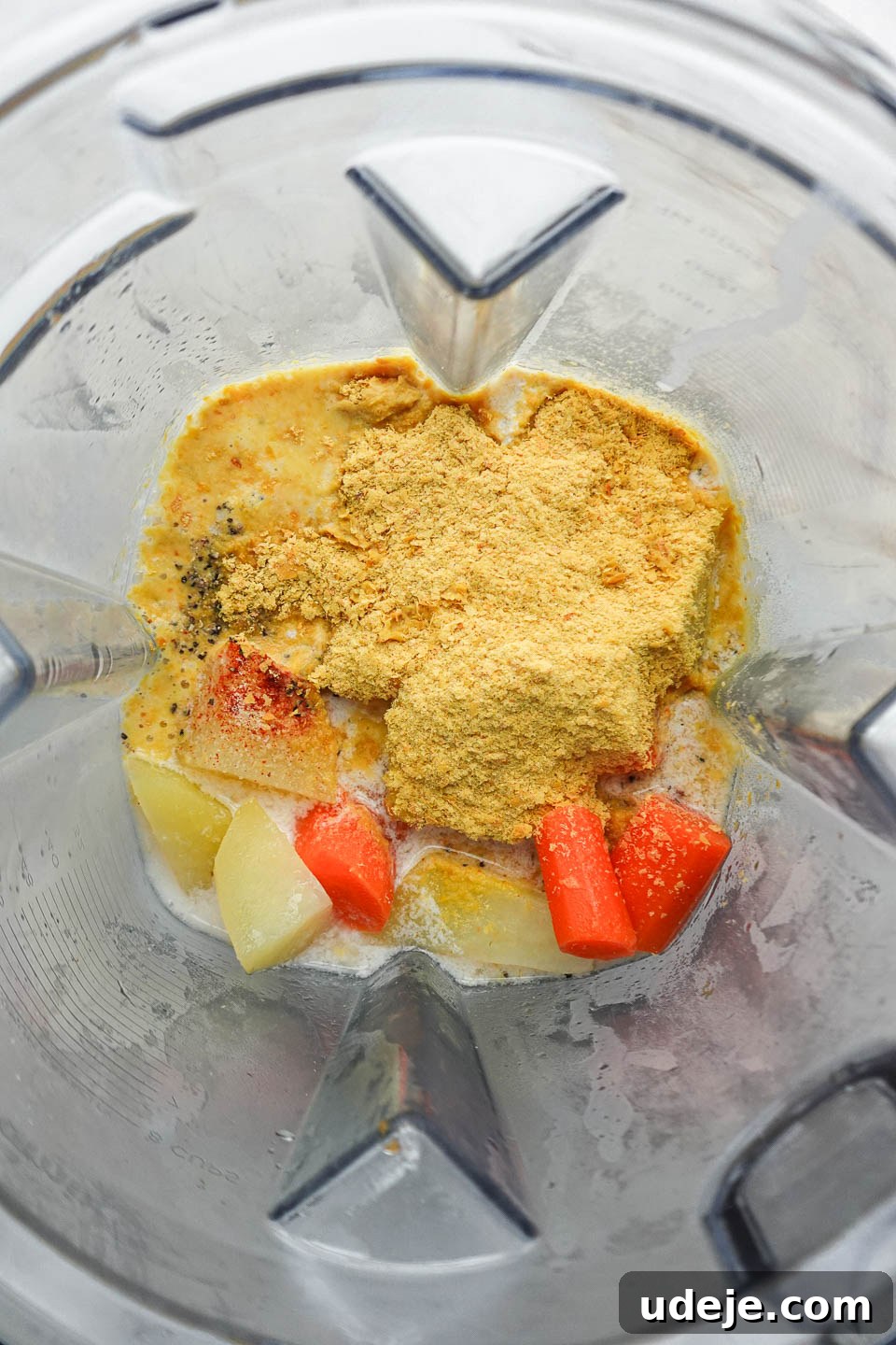 Golden Vegan Cheese Sauce Potato And Carrot Infusion 7 Transferring steamed vegetables into a high-speed blender for the dairy-free cheese sauce