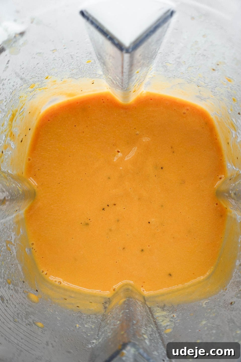 Golden Vegan Cheese Sauce Potato And Carrot Infusion 8 High-speed blender actively blending the dairy-free cheese sauce ingredients