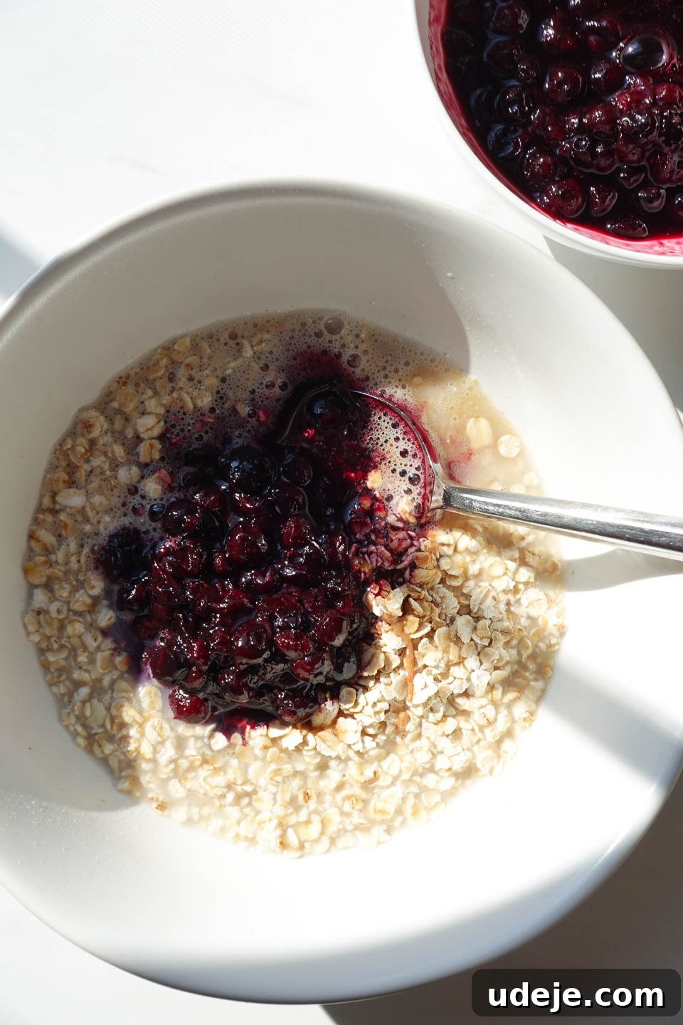Blueberry Muffin Bliss Overnight Oats 8 Stirring oats and blueberry compote together in a bowl