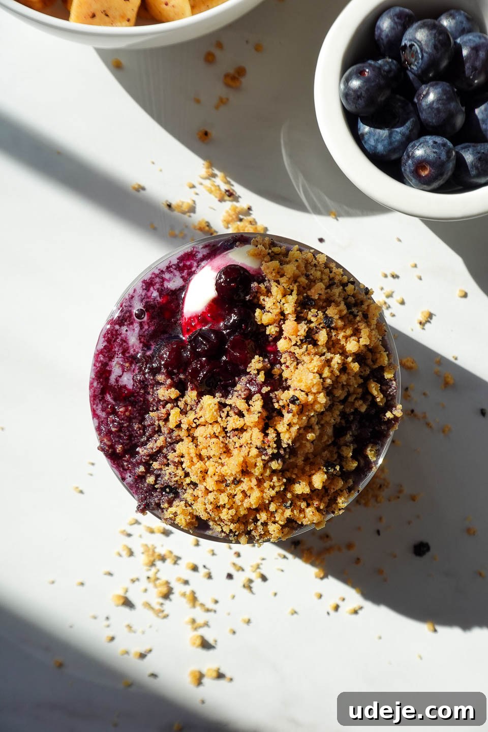 Blueberry Muffin Bliss Overnight Oats 10 overhead shot of blueberry overnight oats topped with vegan yogurt, blueberry compote, and crushed protein cereal