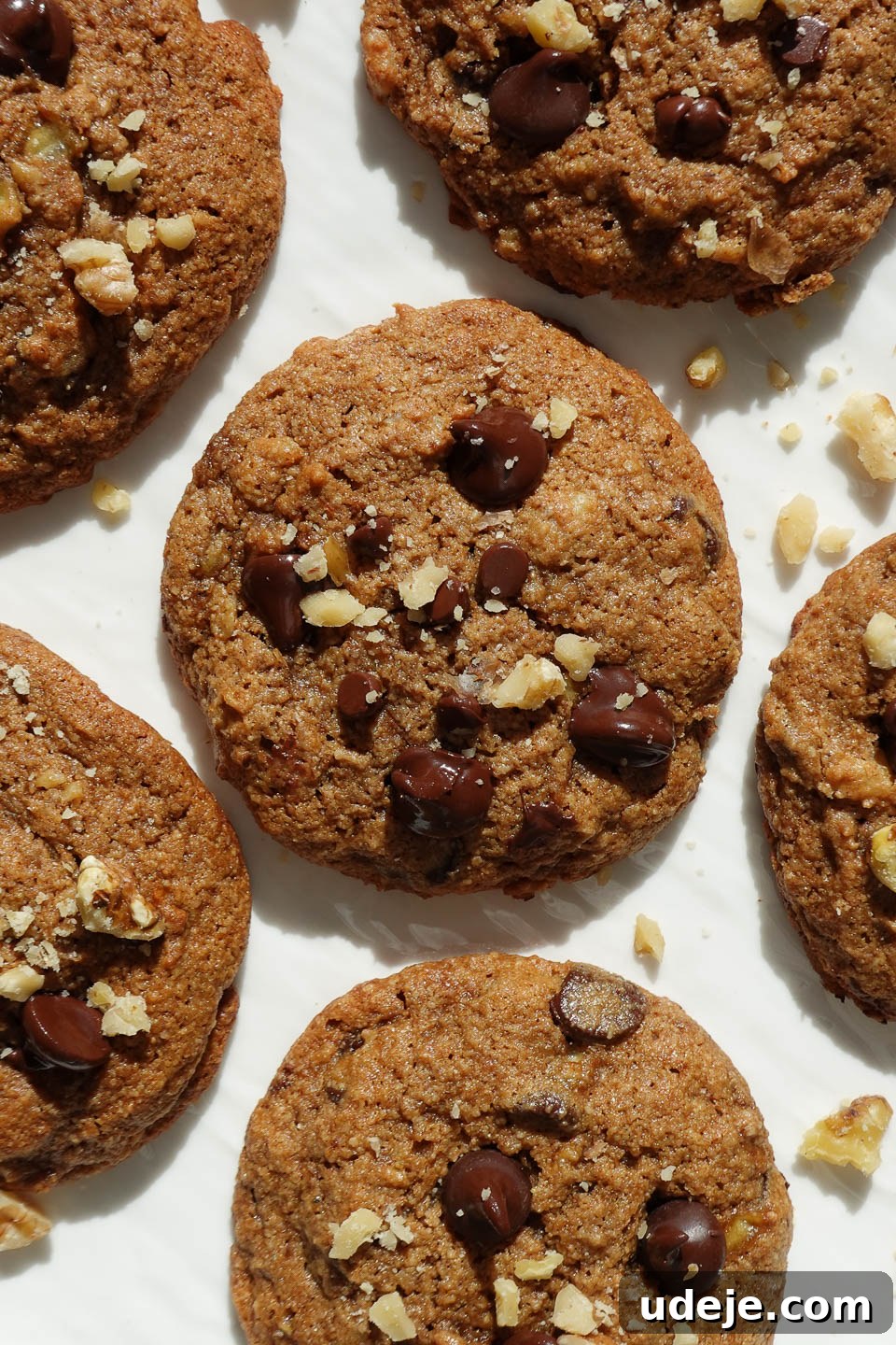 Soft-Baked Vegan Banana Bread Cookies 2 Soft and chewy vegan banana bread cookies beautifully arranged on a white plate, garnished with crushed walnuts for an inviting look.