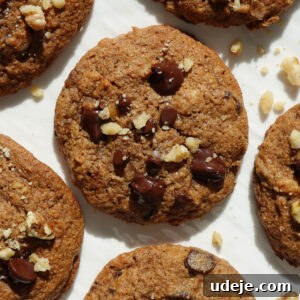 Soft-Baked Vegan Banana Bread Cookies 12 Soft and chewy vegan banana bread cookies on a white plate, garnished with crushed walnuts.