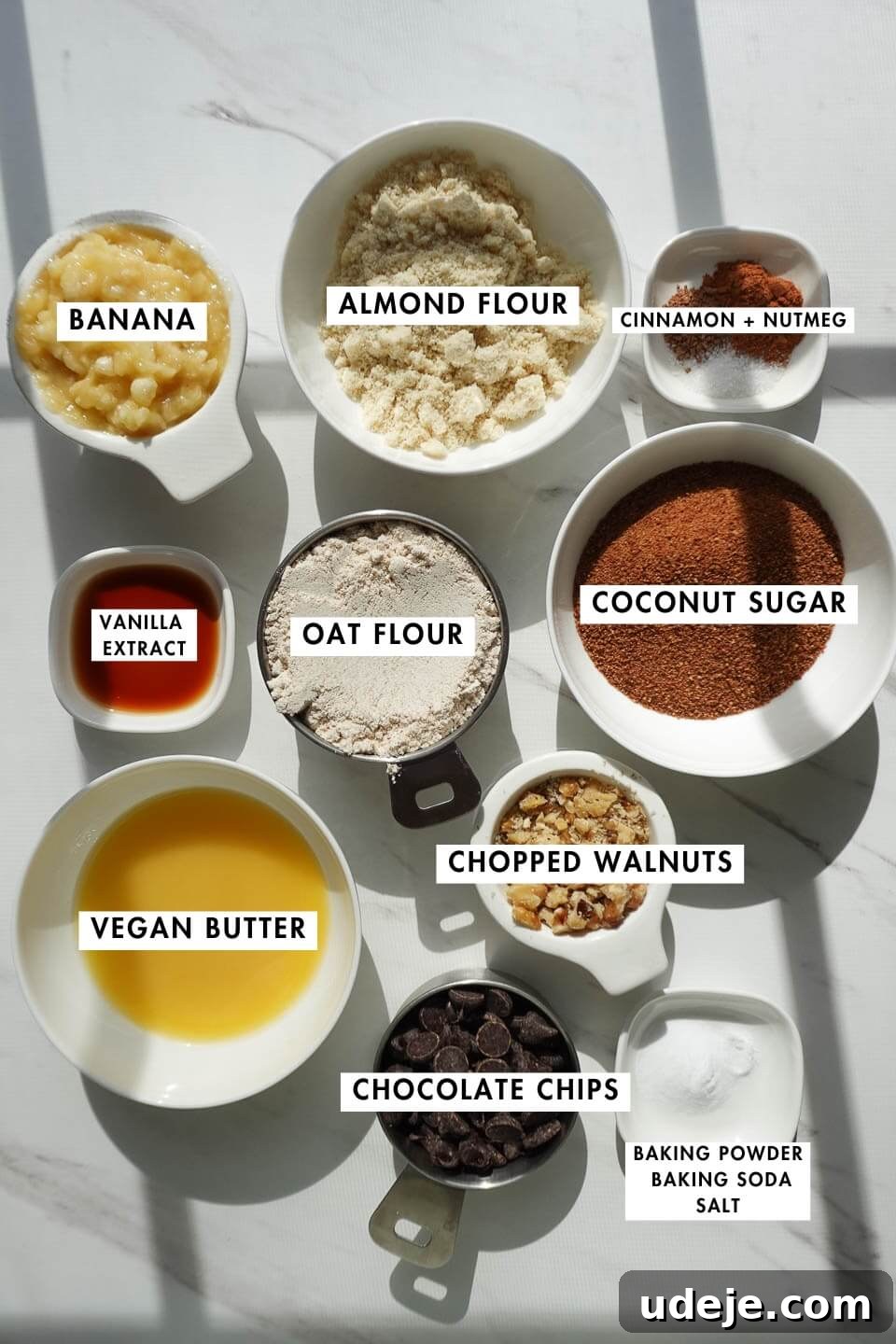 Soft-Baked Vegan Banana Bread Cookies 5 A vibrant flat lay showcasing all the essential ingredients for banana bread cookies, including oat flour, almond flour, a perfectly ripe banana, and creamy vegan butter, ready for baking.