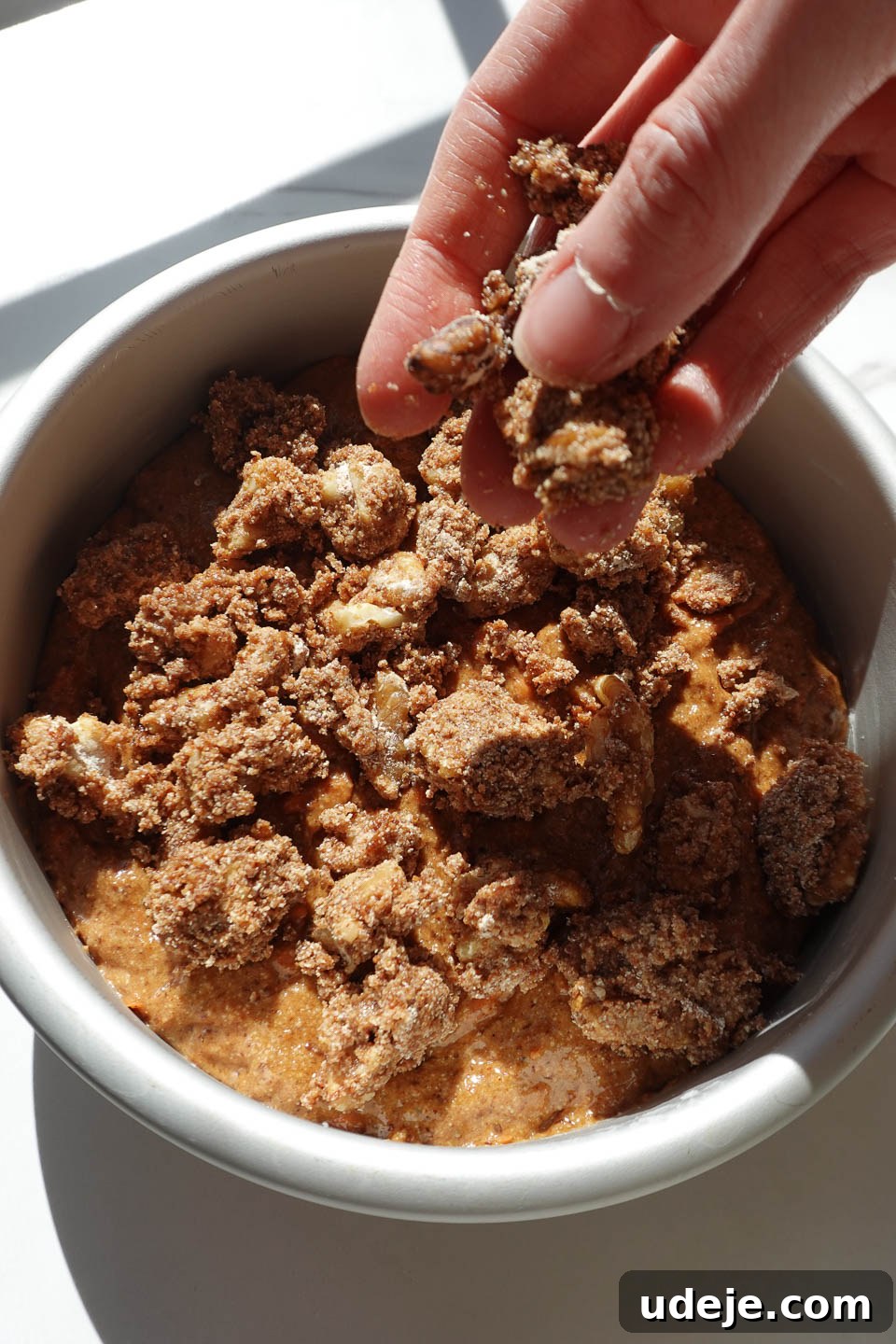 Decadent Spiced Carrot Coffee Cake Vegan Gluten Free 8 Adding walnut crumble topping over carrot coffee cake batter before baking.