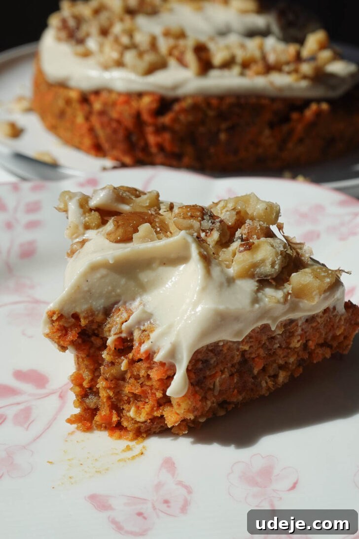 Dreamy No Bake Carrot Cake 6 Slice of raw carrot cake showing soft, moist texture topped with vegan cream cheese frosting and chopped walnuts
