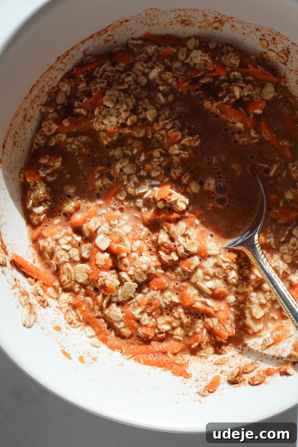 Overnight Carrot Cake Indulgence 6 Mixing carrot cake overnight oats with oats, grated carrots, milk, and spices