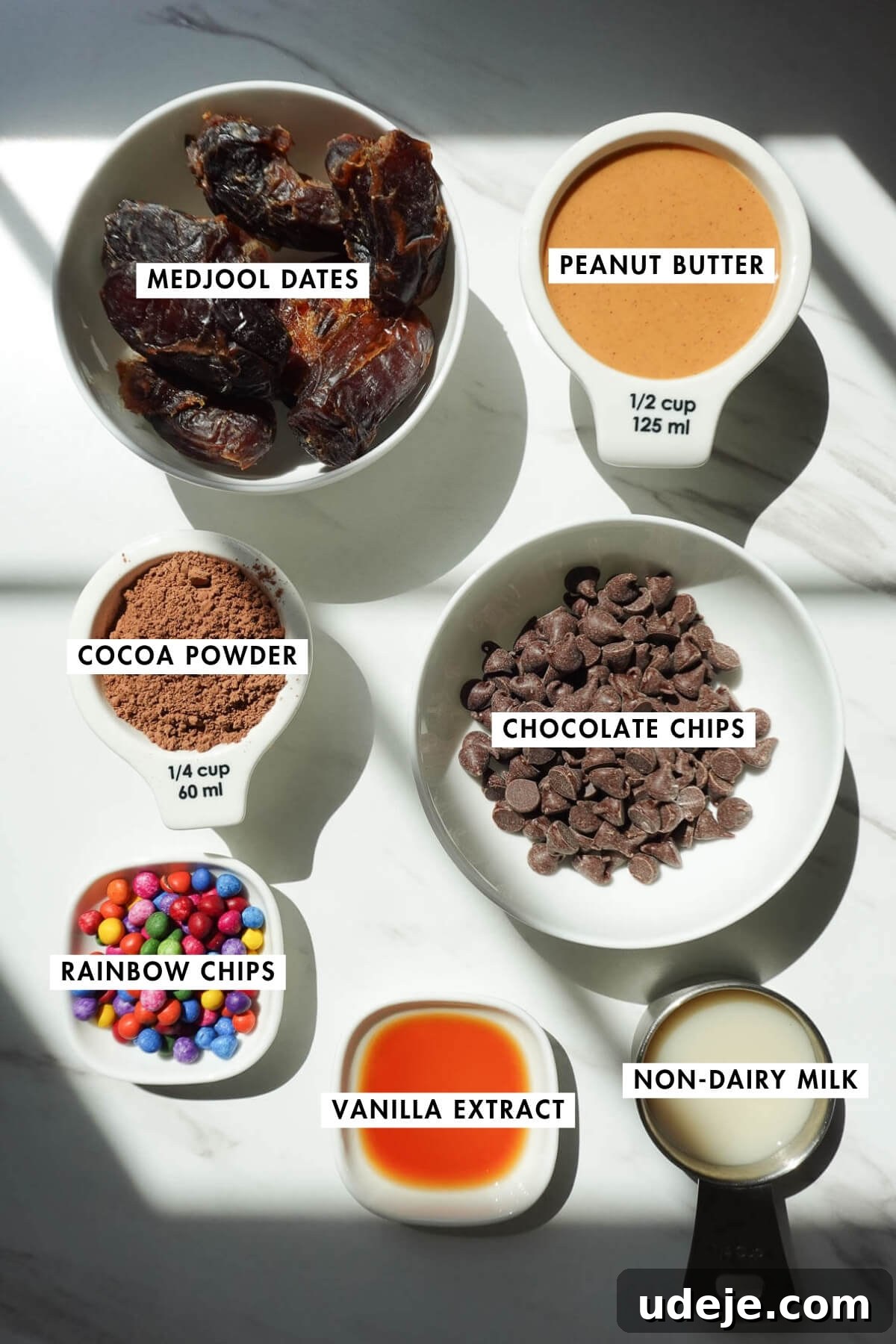 No-Bake Vegan Gluten-Free Cosmic Brownies (Small Batch) 5 Measured ingredients to make no bake cosmic brownies including medjool dates, cocoa powder, peanut butter, chocolate chips, non-dairy milk, vanilla, and sprinkles.