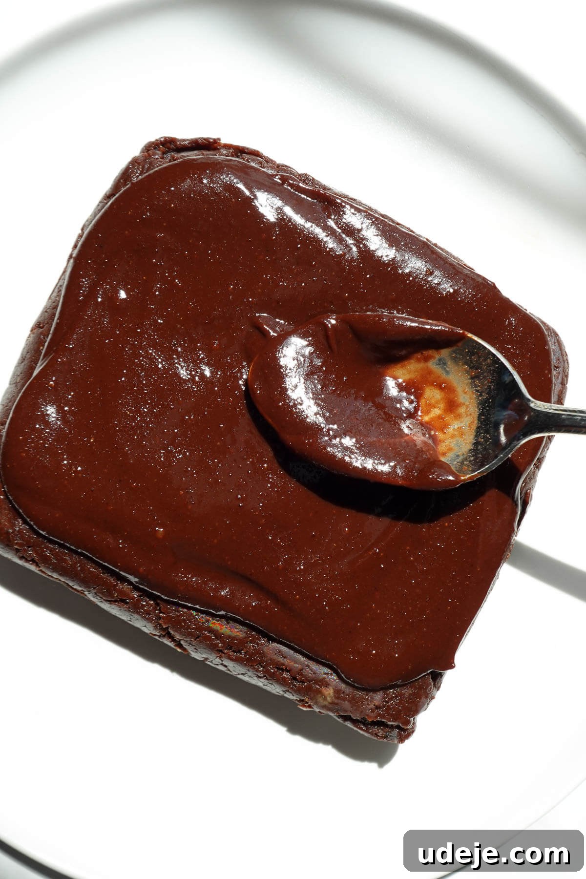 No-Bake Vegan Gluten-Free Cosmic Brownies (Small Batch) 8 Using a spoon to spread the chocolate ganache on top of the vegan cosmic brownie.