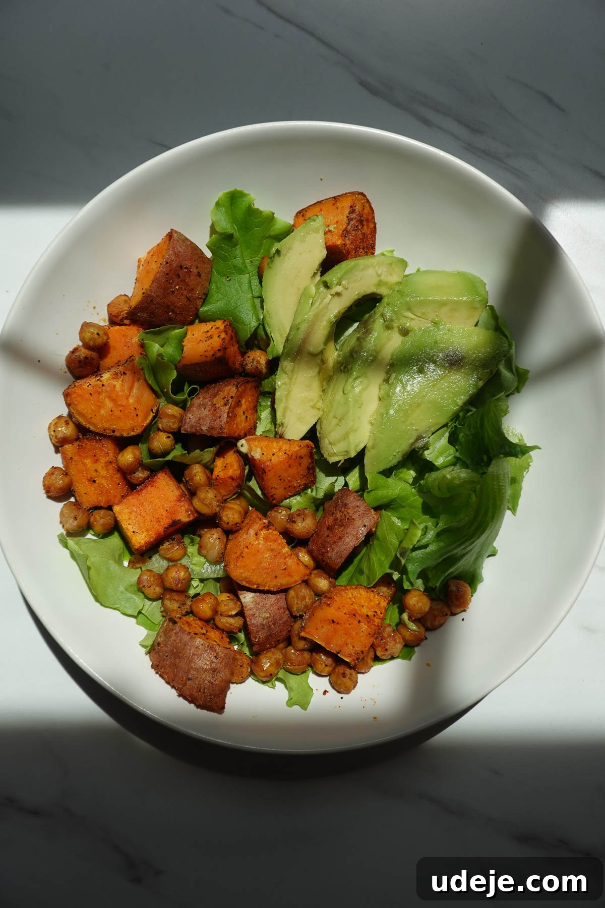 Roasted Sweet Potato & Chickpea Salad with Vegan Honey-Mustard Dressing 9 Salad topped with roasted sweet potatoes, crispy chickpeas, and sliced avocado.