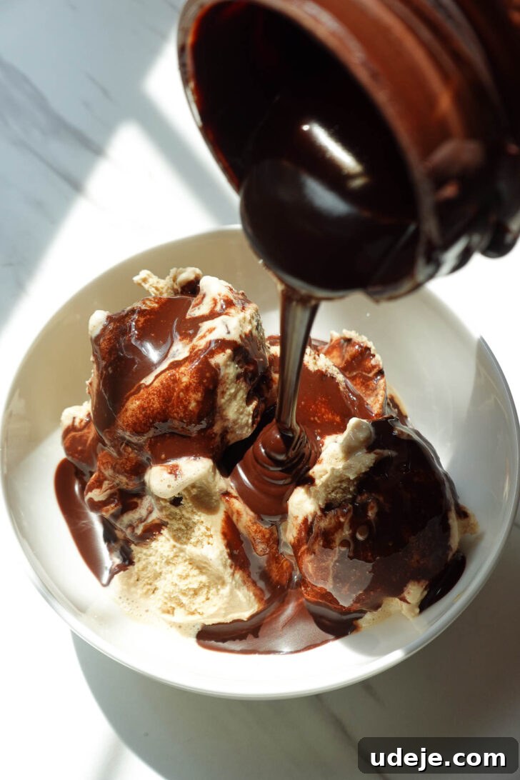 Drizzling homemade chocolate syrup on top of ice cream.