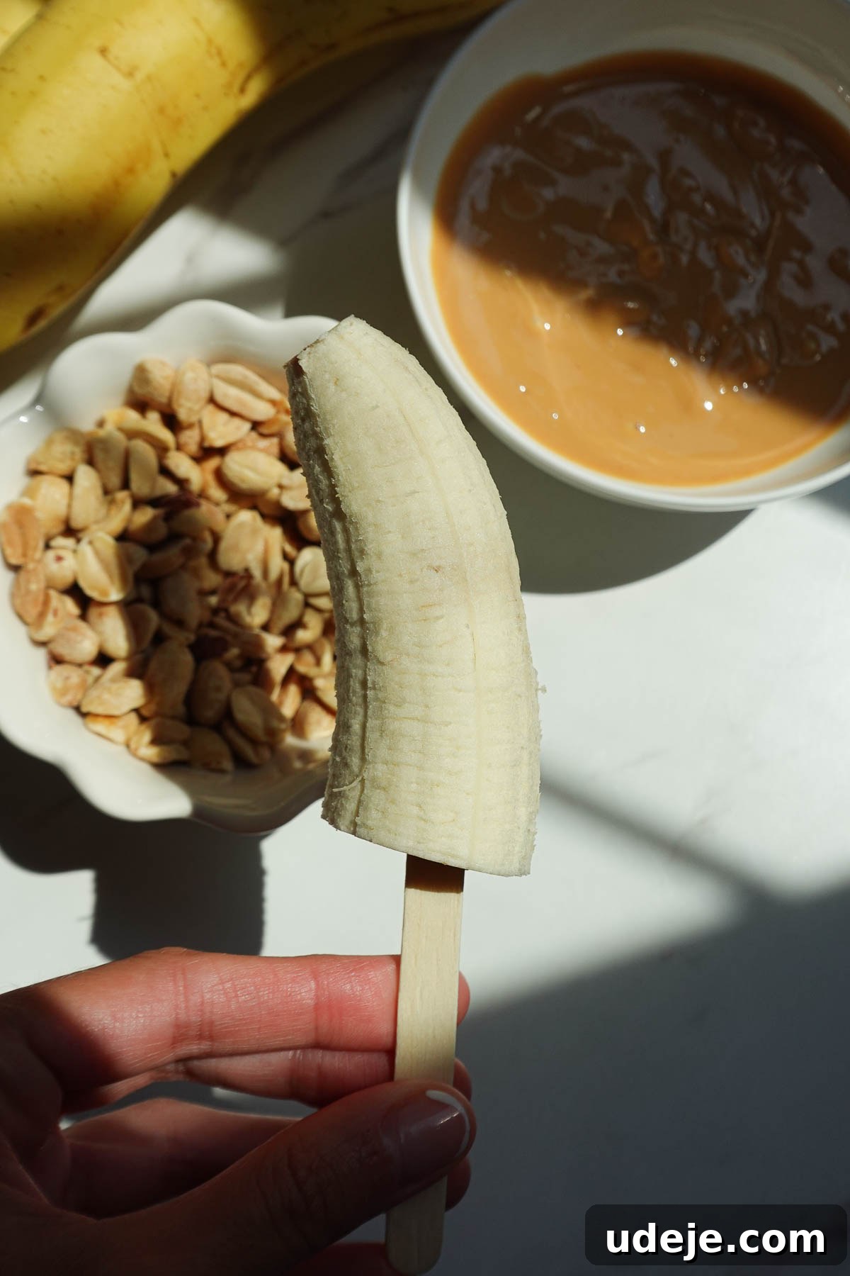 Snickers-Stuffed Frozen Banana Pops 6 Banana halves on popsicle sticks