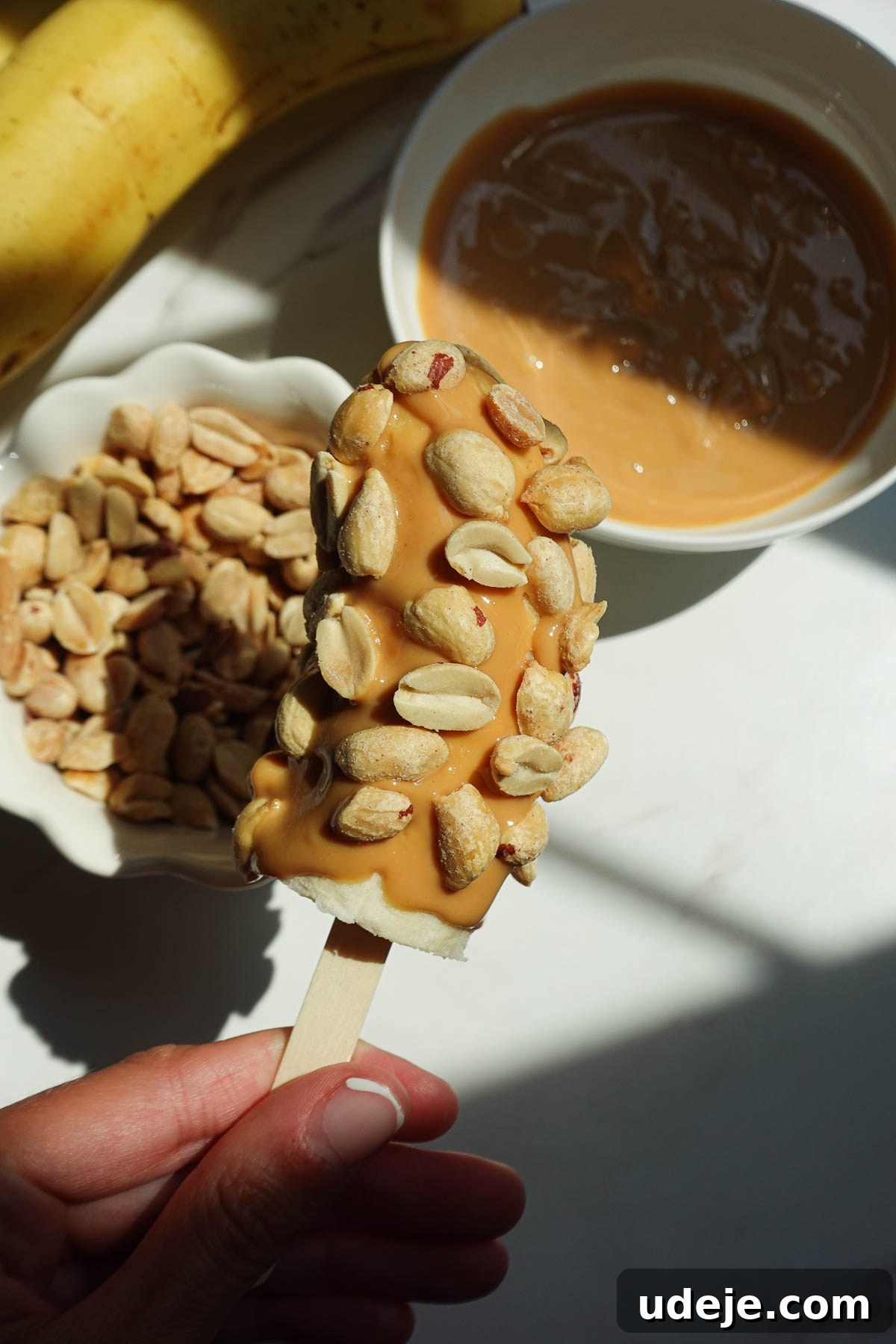 Snickers-Stuffed Frozen Banana Pops 8 Pressing peanuts into peanut butter-coated banana