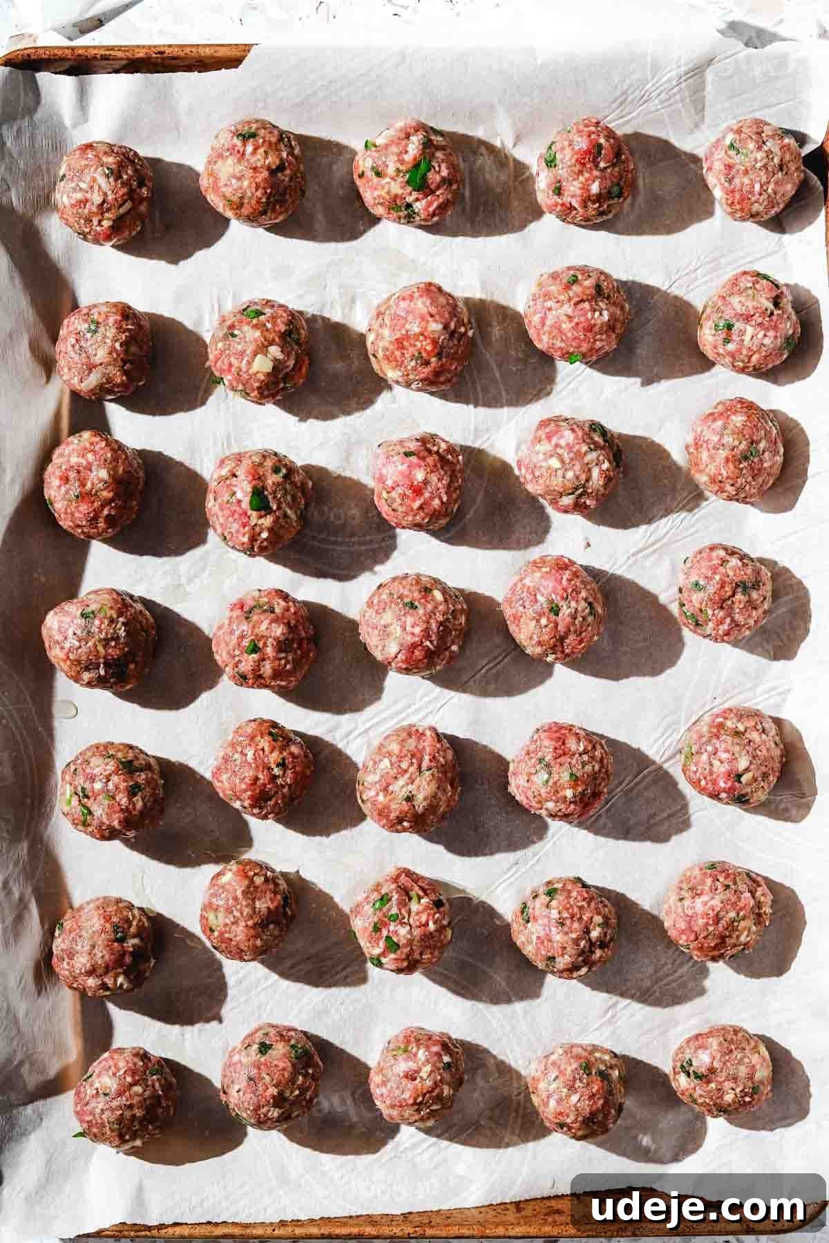 One-Pot Lemony Greek Meatballs and Potatoes (Stovetop) 4 ground beef kofta meatballs on a large baking sheet lined with parchment paper