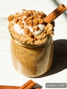 Creamy pumpkin pie overnight oats in a glass jar topped with granola and yogurt
